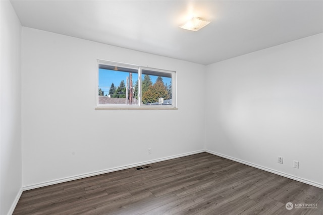 unfurnished room with dark hardwood / wood-style flooring