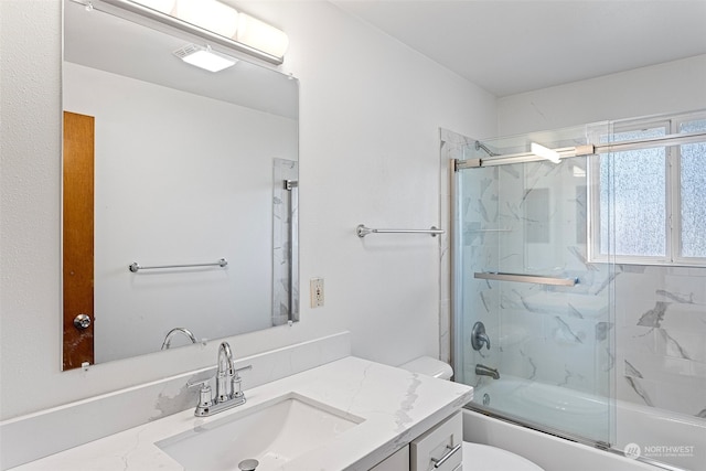 full bathroom with vanity, combined bath / shower with glass door, and toilet