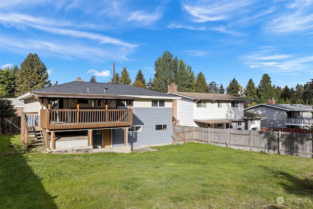 rear view of property featuring a wooden deck and a lawn