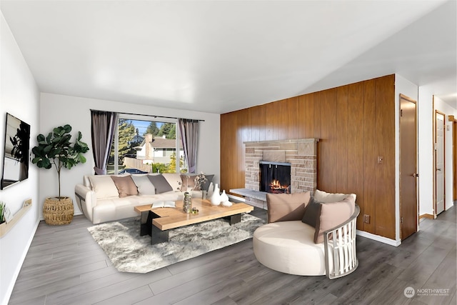 living room featuring a fireplace, wood walls, and dark hardwood / wood-style flooring