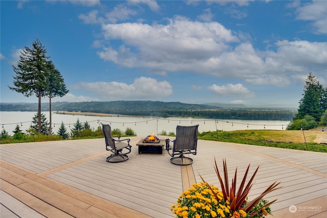 deck with a water view and an outdoor fire pit