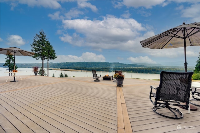 wooden deck featuring a water and mountain view