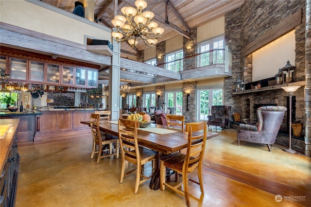 dining space with wood ceiling, high vaulted ceiling, a stone fireplace, beamed ceiling, and a chandelier