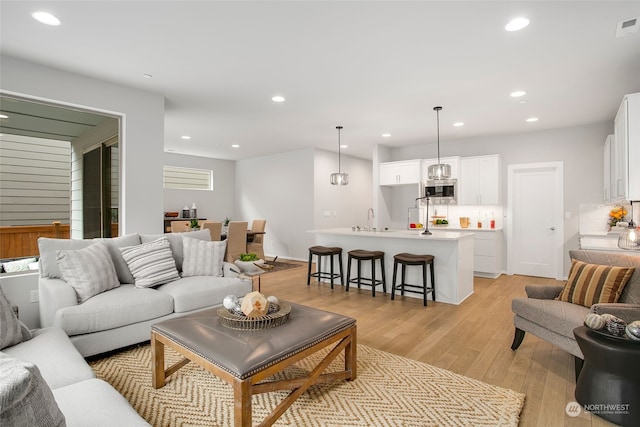 living room with sink and light hardwood / wood-style flooring