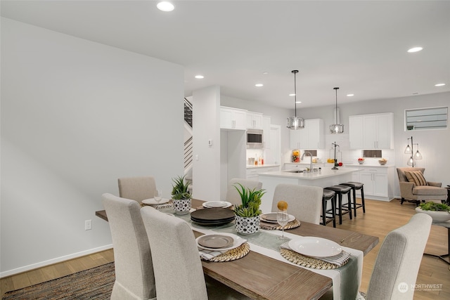 dining room featuring sink and light hardwood / wood-style flooring