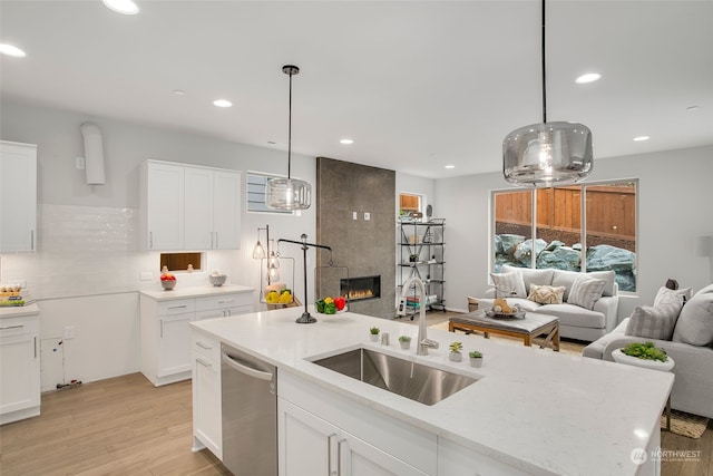 kitchen featuring white cabinetry, sink, hanging light fixtures, and dishwasher