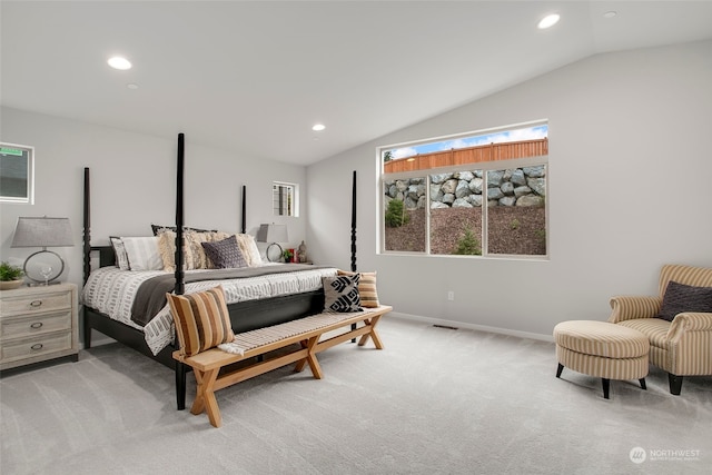 carpeted bedroom featuring lofted ceiling and multiple windows