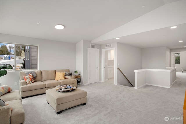 carpeted living room featuring a wealth of natural light and lofted ceiling