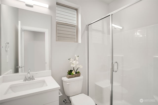 bathroom with vanity, toilet, and a shower with shower door