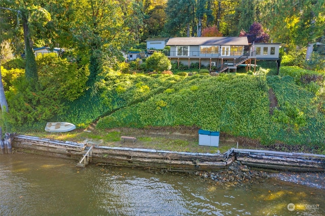 rear view of house featuring a deck with water view