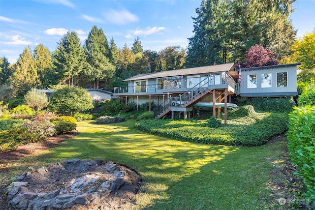 back of property featuring a lawn and a deck