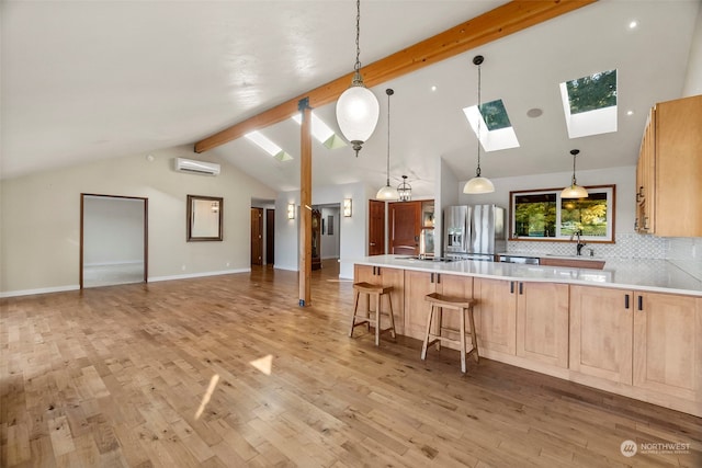 kitchen with beamed ceiling, a wall unit AC, stainless steel fridge, light hardwood / wood-style flooring, and backsplash