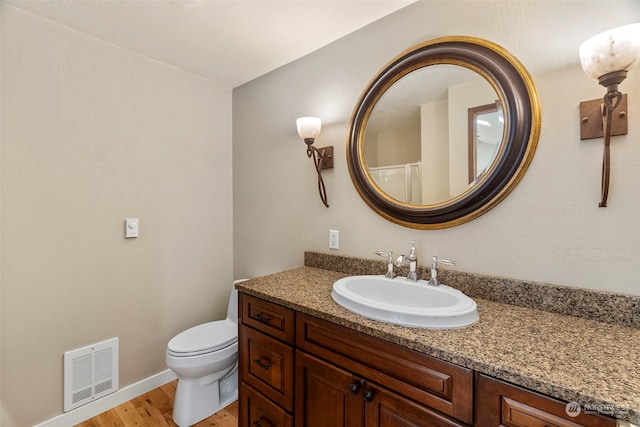 bathroom featuring hardwood / wood-style floors, vanity, and toilet