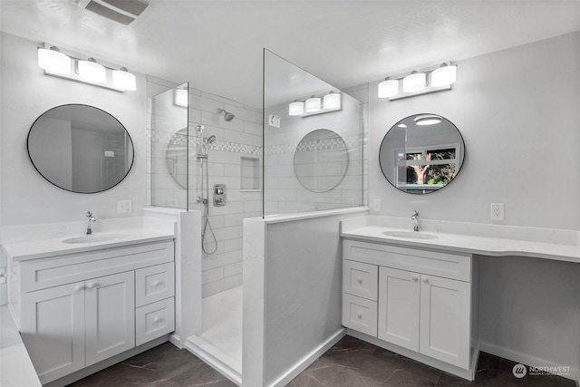 bathroom with vanity and a tile shower