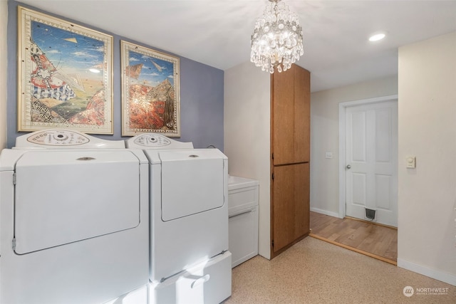 laundry area featuring cabinets, a chandelier, and washing machine and clothes dryer