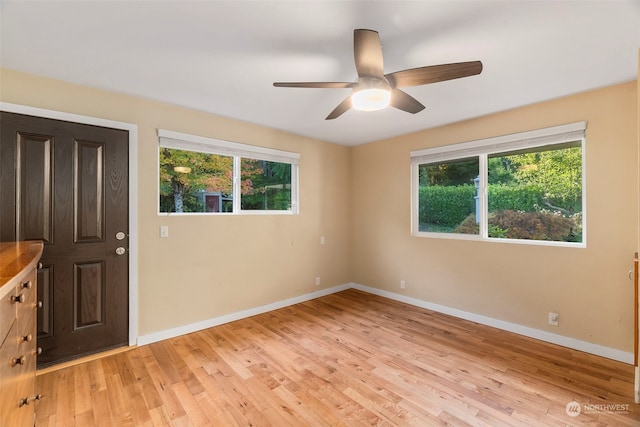 unfurnished room with ceiling fan, light wood-type flooring, and a healthy amount of sunlight