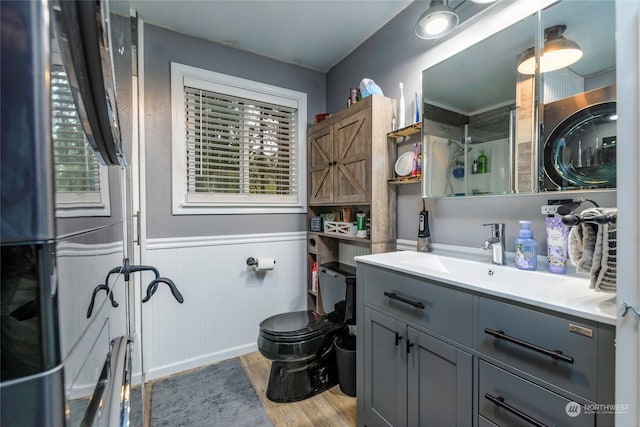 bathroom with hardwood / wood-style flooring, plenty of natural light, vanity, and toilet