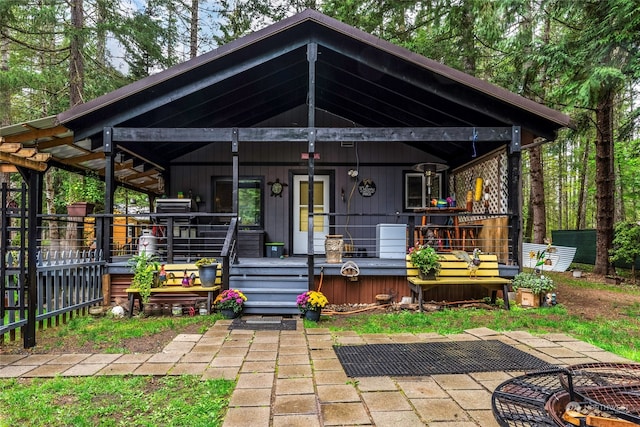 back of house with a deck and a patio