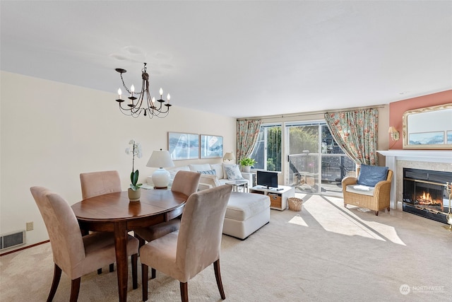 carpeted dining area featuring a notable chandelier and a tiled fireplace