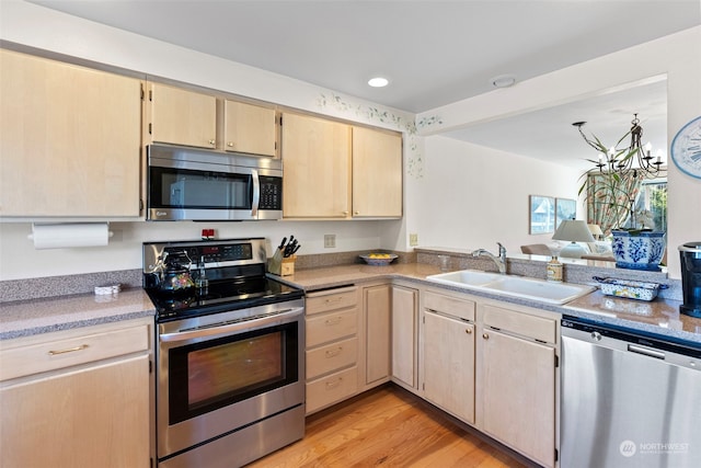 kitchen featuring stainless steel appliances, light hardwood / wood-style floors, light brown cabinetry, and sink