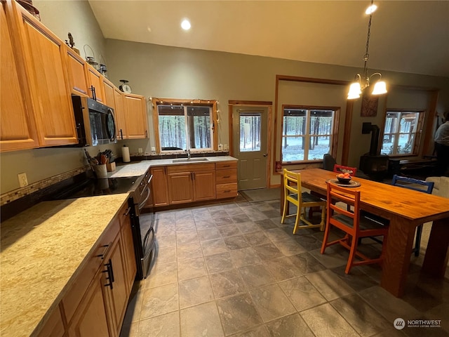 kitchen featuring pendant lighting, a chandelier, electric range, and sink