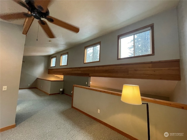 bonus room featuring light carpet and ceiling fan