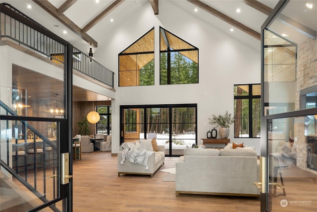 living room featuring beam ceiling, light wood-type flooring, and high vaulted ceiling