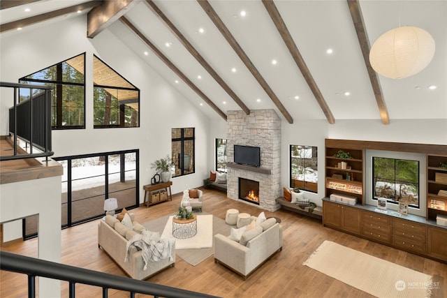 living room with a fireplace, beamed ceiling, high vaulted ceiling, and light hardwood / wood-style floors