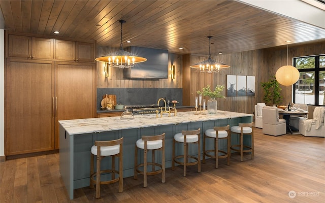 kitchen with pendant lighting, wooden ceiling, and wood walls