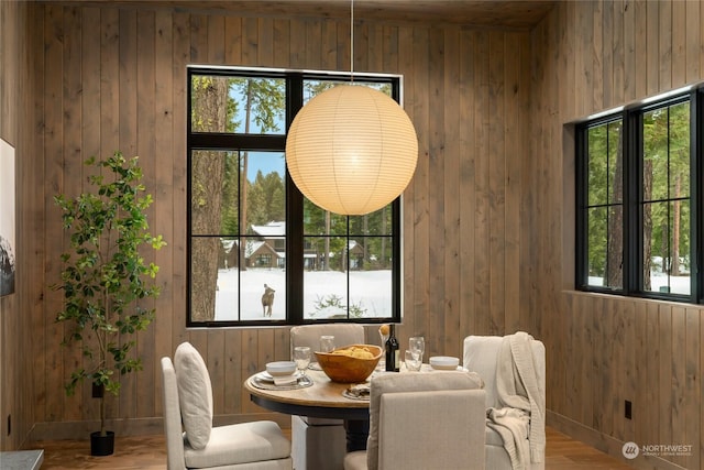 dining area featuring wood-type flooring and wood walls