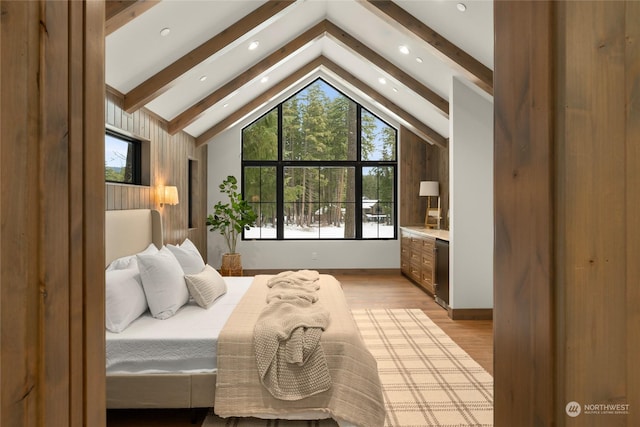 bedroom with beam ceiling, high vaulted ceiling, and light hardwood / wood-style flooring