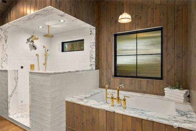 bathroom with shower with separate bathtub and wooden walls