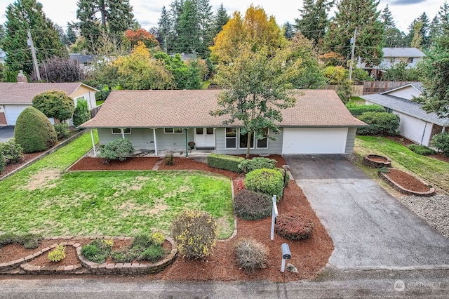 ranch-style home featuring a front lawn, covered porch, and a garage