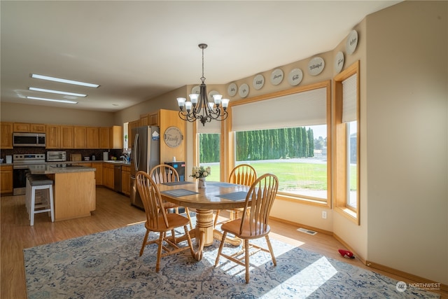 dining area featuring a notable chandelier and light hardwood / wood-style floors