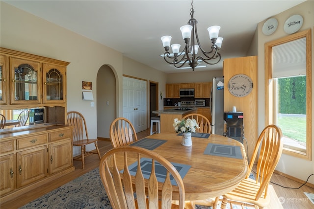 dining space featuring light hardwood / wood-style floors and a notable chandelier