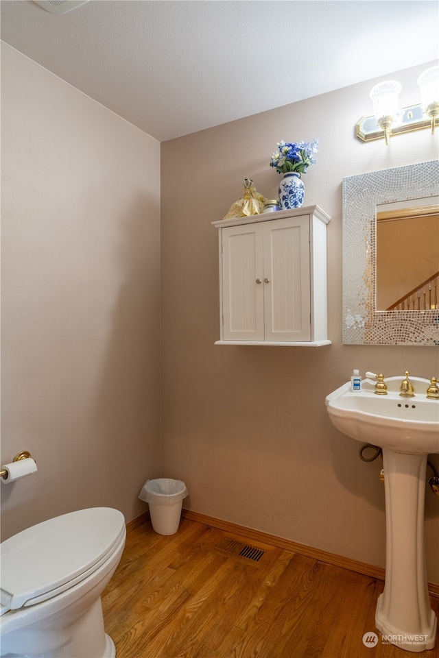 bathroom with sink, hardwood / wood-style flooring, and toilet