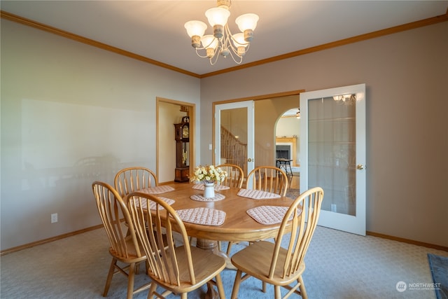 dining area with ornamental molding, light colored carpet, and french doors