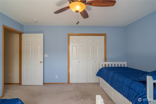 carpeted bedroom featuring ceiling fan and a closet