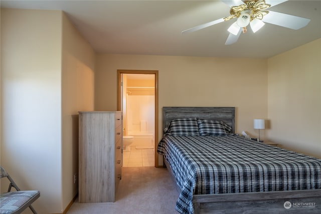 carpeted bedroom with ensuite bath and ceiling fan