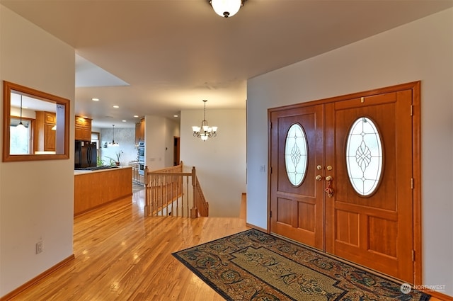 foyer with a notable chandelier, light hardwood / wood-style flooring, and a wealth of natural light