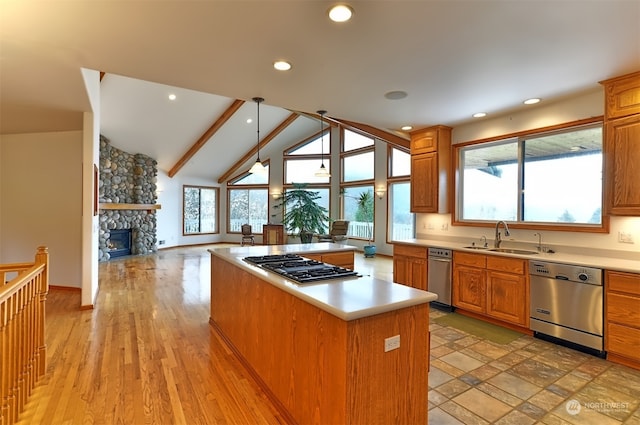 kitchen featuring lofted ceiling with beams, stainless steel appliances, a healthy amount of sunlight, and a kitchen island