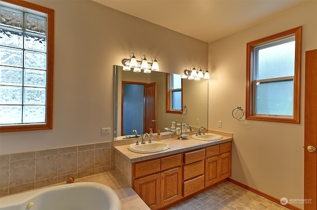 bathroom with tiled tub and vanity