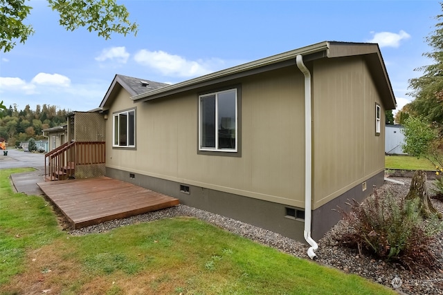 view of home's exterior featuring a deck and a yard