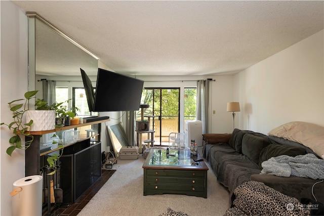 living room featuring a textured ceiling, dark colored carpet, and plenty of natural light