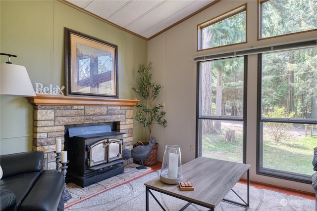 living area featuring vaulted ceiling, a wood stove, and crown molding