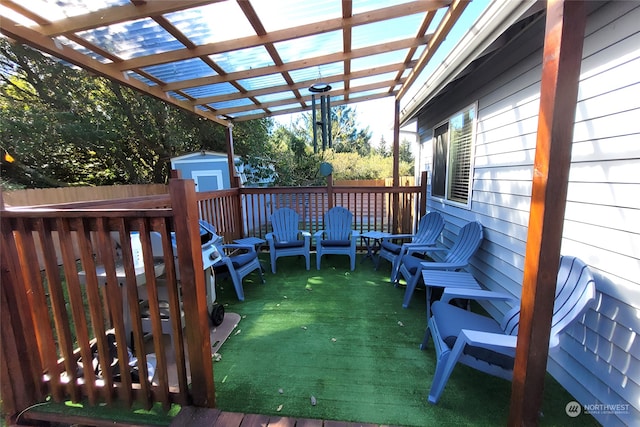 wooden deck with a pergola and a shed