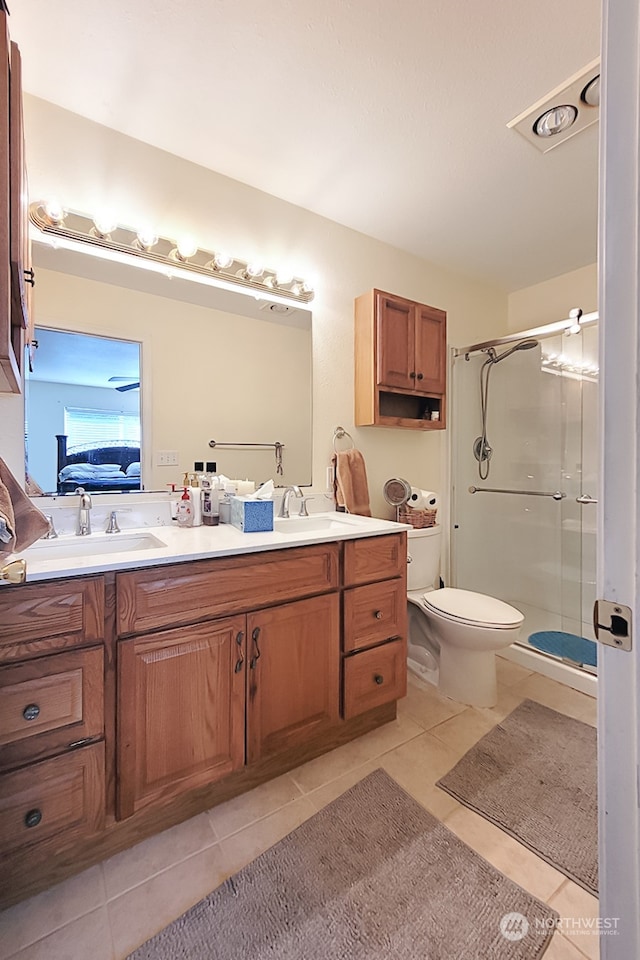 bathroom with vanity, walk in shower, tile patterned flooring, and toilet