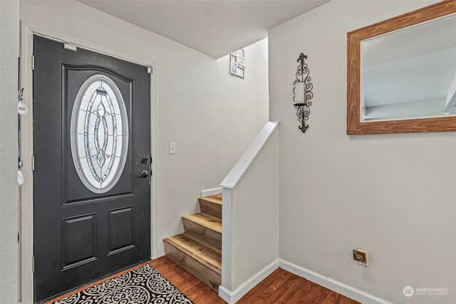 foyer entrance featuring a textured ceiling and wood-type flooring