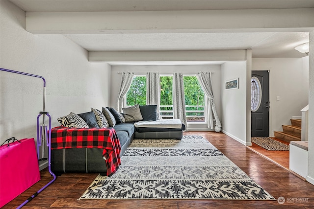 living room with beam ceiling and dark hardwood / wood-style flooring