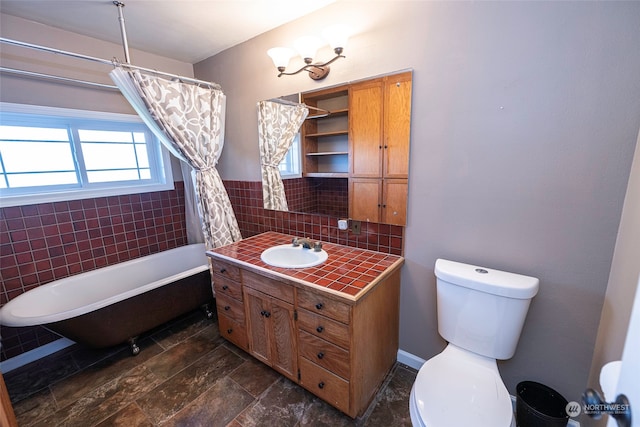 bathroom featuring vanity, tile walls, and toilet